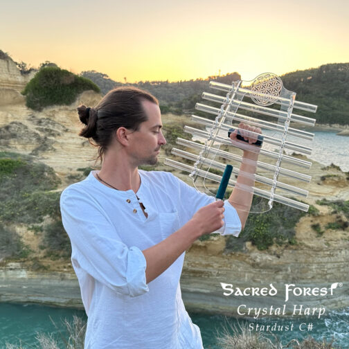 Sound Healer playing Sacred Forest Crystal Harp standing on beautiful clif landscape